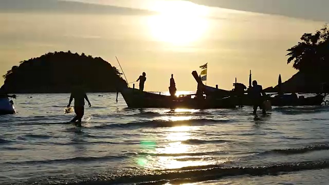 在泰国普吉岛海滩上的日落剪影船。视频素材