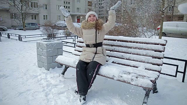 小女孩在长凳上下雪的慢动作视频素材