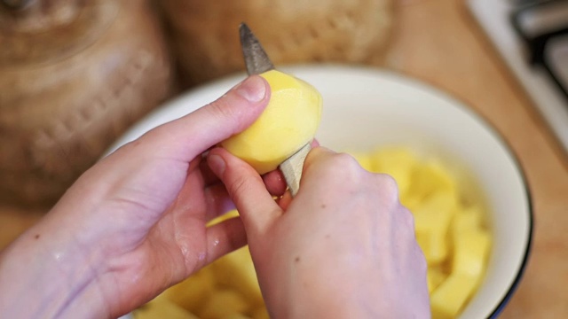 在家厨房削土豆皮。慢动作视频素材