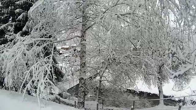 在冬天的时候，山上一个被雪覆盖的村庄。视频素材