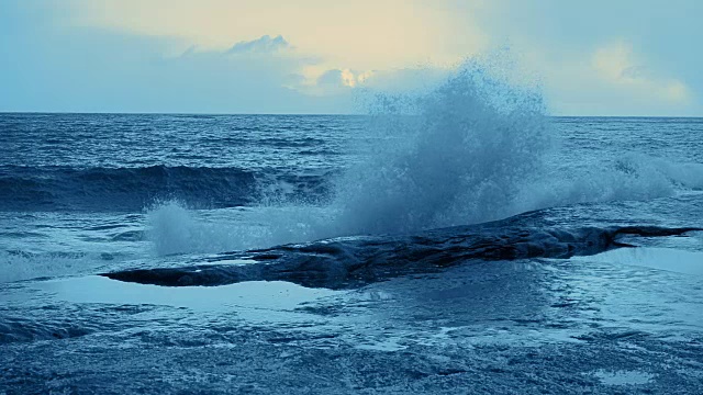 海浪拍打着海岸岩石。有色。慢动作视频素材