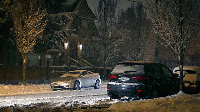 汽车在下雪时穿过郊区视频素材