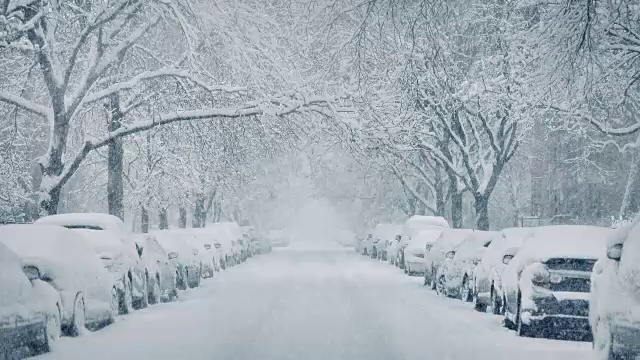 暴风雪中汽车被埋在城市大道上视频素材