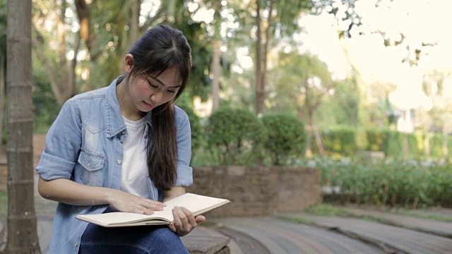 年轻的亚洲女孩阅读和接听电话视频素材