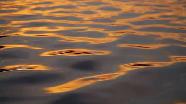 夕阳下的波浪，金色的倒影视频素材