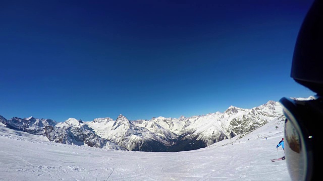 滑雪者站在山顶上，背对着山峰，准备下山。第一人称视角视频素材