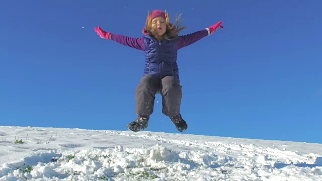 小女孩在雪中跳跃的慢动作视频素材