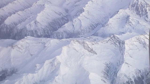 从飞机上看日落时被白雪覆盖的阿尔卑斯山和飞机引擎视频素材