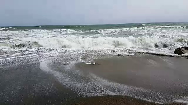 海浪拍打着多岩石的海滩视频素材