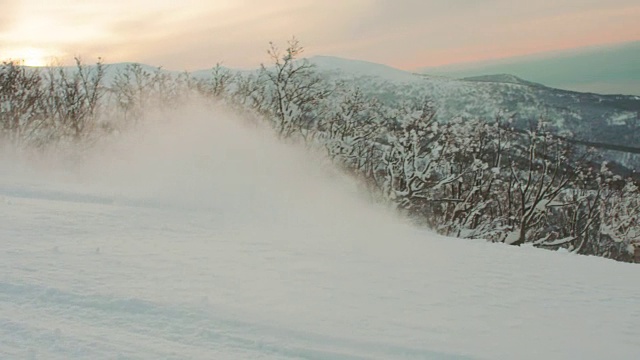 滑雪板斜线转弯在日落前的剪影橙色的云高速行动冬季高山运动视频素材