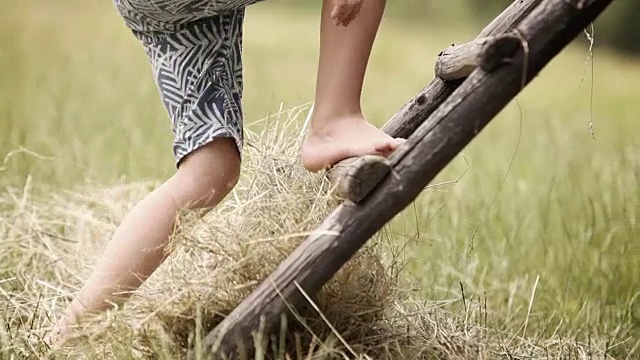 一个男孩正在爬乡下房子里的木梯视频素材