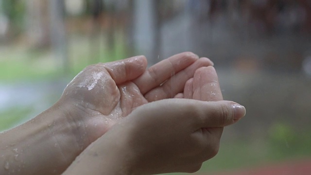 滴水在手。雨滴缓慢地落在一个女人的手上。视频素材