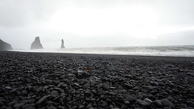 4K黑沙熔岩海滩在维克，冰岛。低角度，倾斜的地标海滩附近的玄武岩海栈视频素材