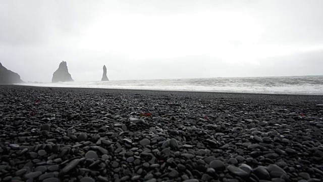 4K黑沙熔岩海滩在维克，冰岛。低角度，倾斜的地标海滩附近的玄武岩海栈视频素材