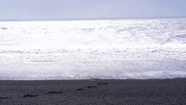 4K黑沙熔岩海滩在维克，冰岛。低角度，倾斜的地标海滩附近的玄武岩海栈视频素材