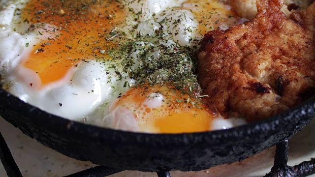 在平底锅里煎鸡蛋和香料炸鸡块视频素材