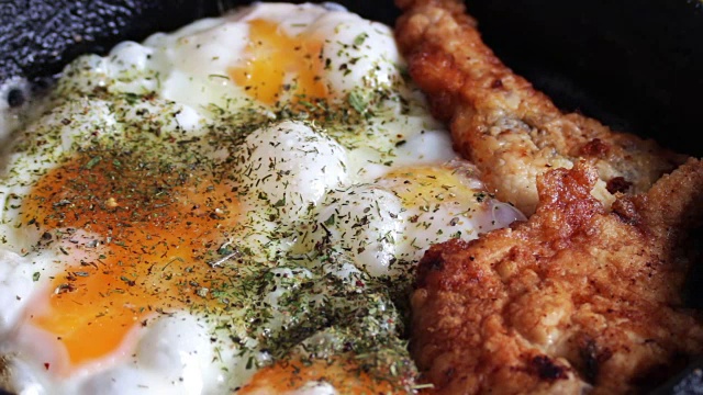 在平底锅里煎鸡蛋和香料炸鸡块视频素材