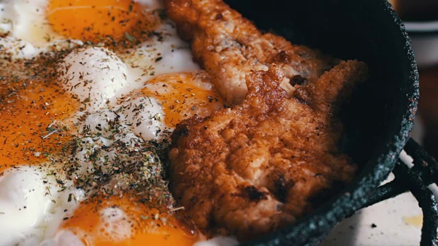 在平底锅里煎鸡蛋和香料炸鸡块视频素材