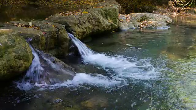 流动的水和瀑布的波浪在美丽的绿色自然视频素材