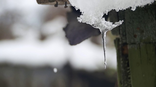 一到春天，雪就从屋顶上融化，滴落下来。慢动作视频素材