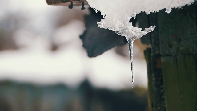 一到春天，雪就从屋顶上融化，滴落下来。慢动作视频素材