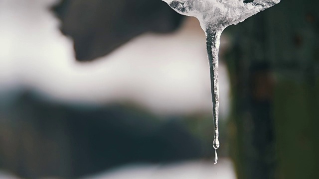 一到春天，雪就从屋顶上融化，滴落下来。慢动作视频素材