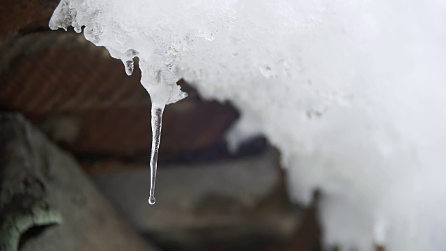 一到春天，雪就从屋顶上融化，滴落下来。慢动作视频素材