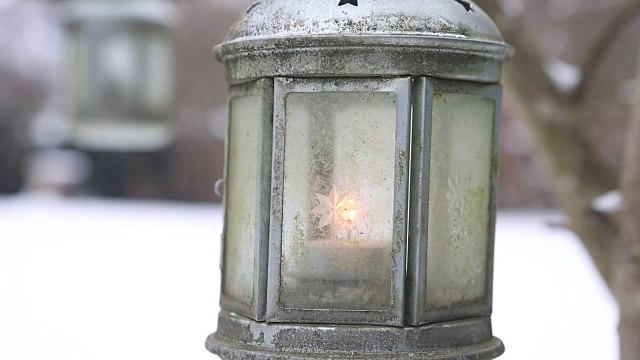 灯笼和蜡烛挂在树上，在花园里的雪视频素材