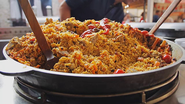 用大锅煮肉饭。米饭配肉和蔬菜在一个大锅里。亚洲传统菜肴——肉饭。国家美味的食物。蒸熟的食物视频素材