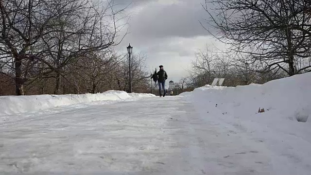 快乐的女孩背着背包在冬天的公园里跑步视频素材