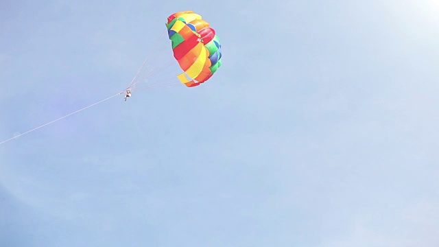 一艘船拖着五彩缤纷的降落伞在空中飞行视频素材