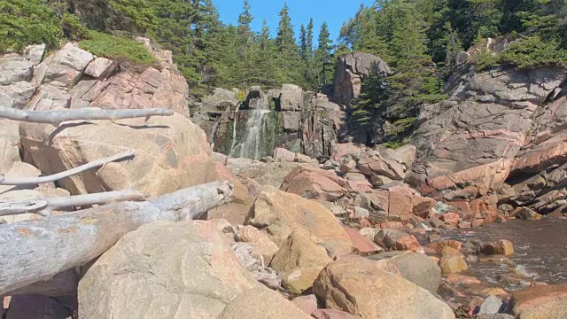 在荒野中，河流从岩石火山岩上倾泻而下，流入大海视频素材