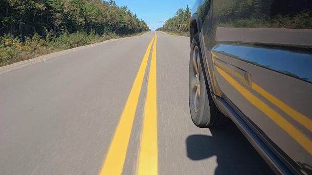 近距离观察:一辆越野车行驶在加拿大偏远的空旷道路上视频素材