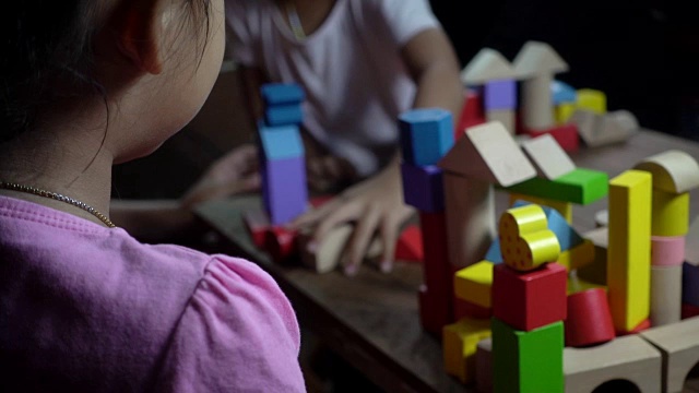 亚洲小女孩在暗室里玩木块，慢动作拍摄。视频素材