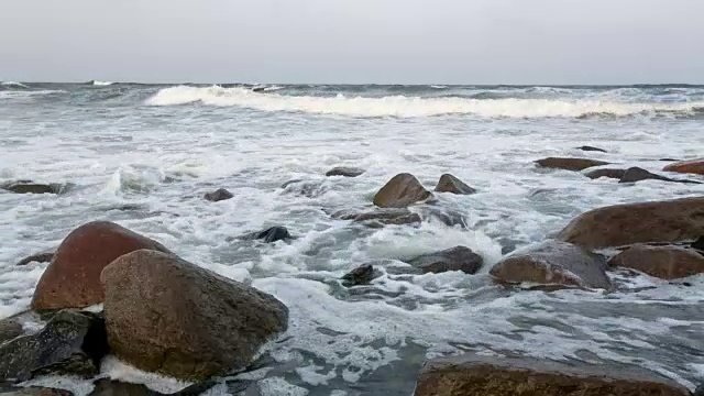 海浪和泡沫在岩石海滩上视频素材