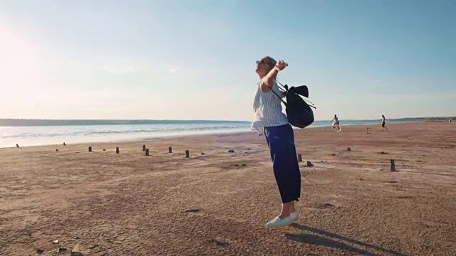 年轻有吸引力的女人跑步，并在阳光下的海滩上有很多乐趣视频素材