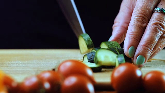 一个女人用菜刀切黄瓜。视频素材