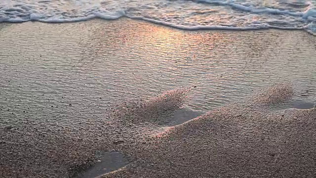 沙滩上的海浪在夕阳下的海洋海洋夏天的足迹视频素材