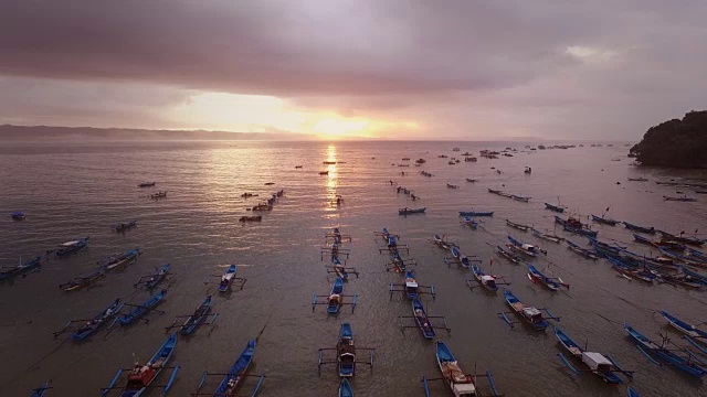 日落时飞过热带海滩上的渔船视频素材