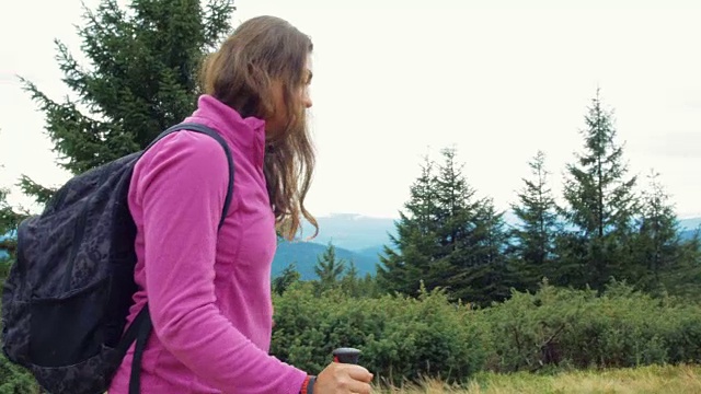 背包女徒步旅行者在山上徒步旅行，欣赏风景视频素材