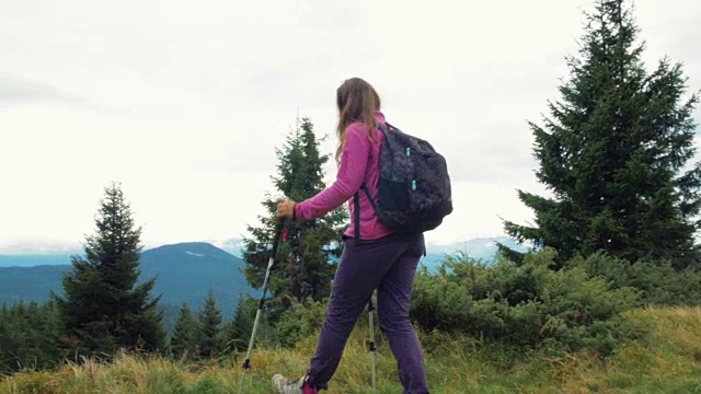 背包女旅行者在山里徒步旅行，欣赏风景视频素材