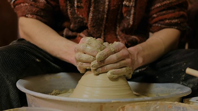 职业男性陶工在陶工轮上用粘土工作视频素材