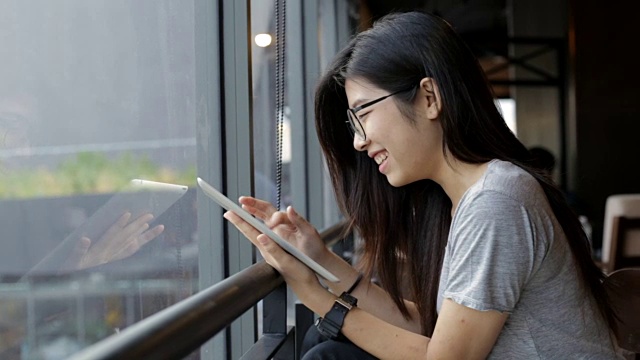 年轻的亚洲女孩喜欢使用数字平板电脑视频素材