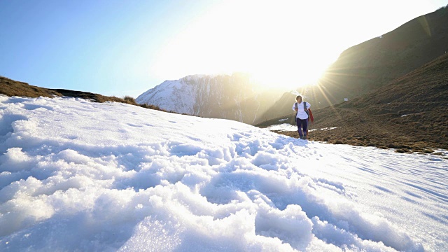 两个徒步者在雪山小径上行走的低角度视图视频素材