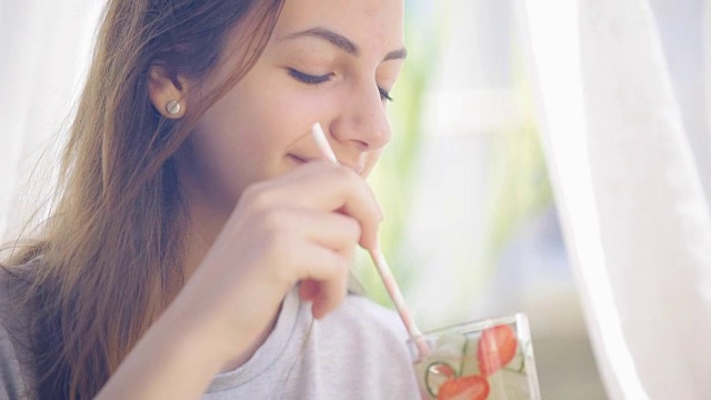 年轻女子喝黄瓜草莓排毒水。视频素材