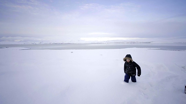 冰岛风景优美，自然冬雪寒冷，屋外小孩在雪中嬉戏视频素材