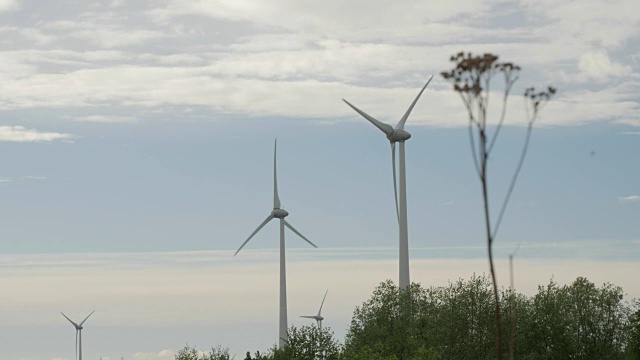 风力发电场、发电机、野地上多云的天空为背景视频素材