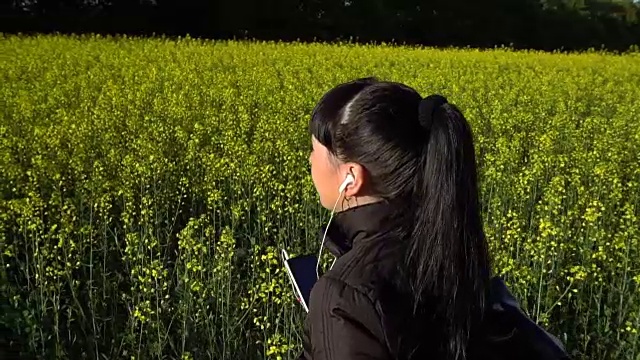 那女孩正走在油菜地上视频素材