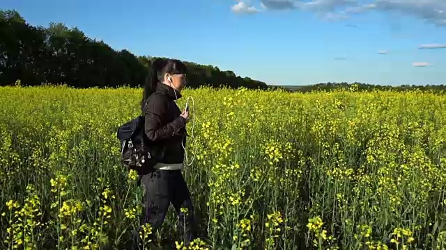 那女孩走在开满鲜花的油菜地里视频素材