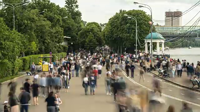 成群的人沿着城市的河堤走着，时光流逝视频素材